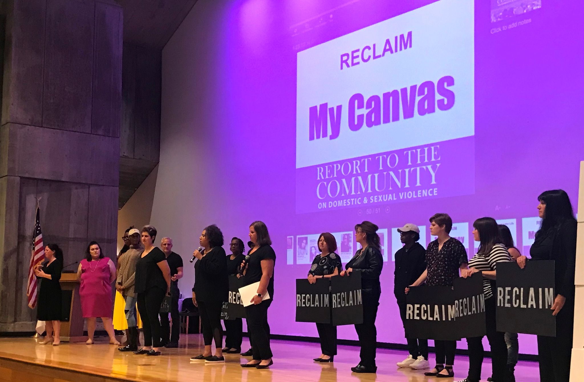 A group of individuals speaking on stage, representing Vera House's report to the community